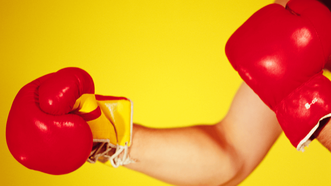 Man's arm punching, wearing punching gloves