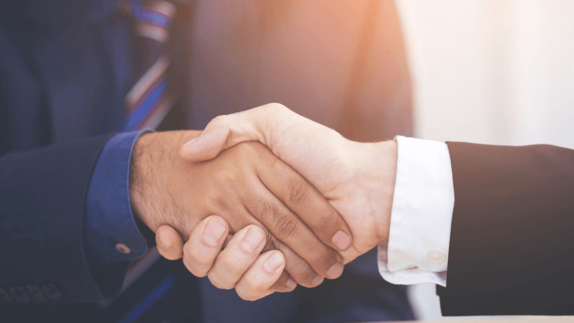 Close up of two people's hands shaking in a professional setting