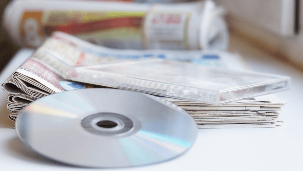 Image of CD resting on top of a stack of newspapers.