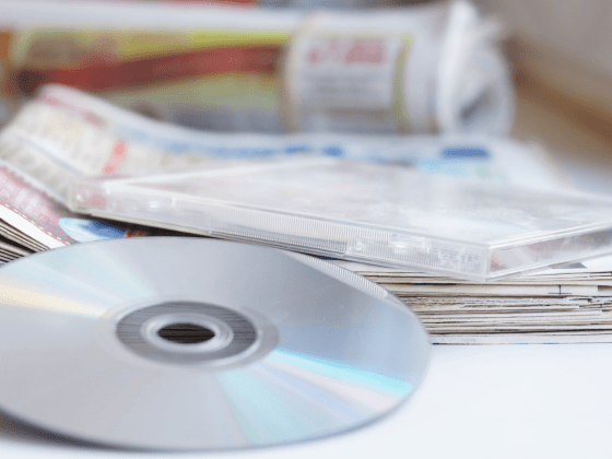 Image of CD resting on top of a stack of newspapers.