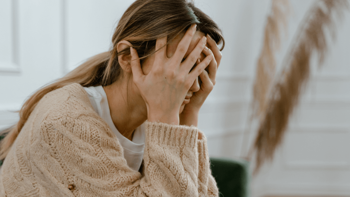 Woman upset, holding her head in her hands