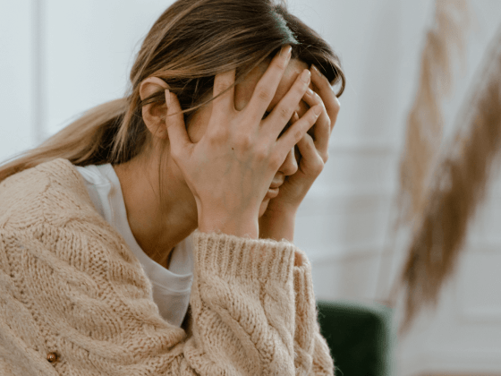 Woman upset, holding her head in her hands