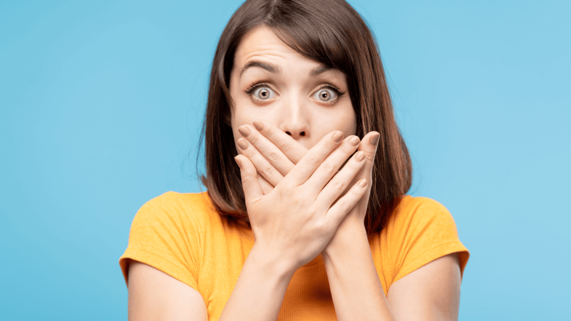 Woman covering her mouth as if something happened by accident.