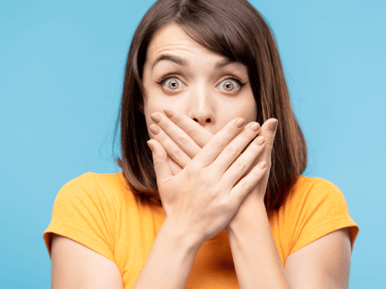 Woman covering her mouth as if something happened by accident.