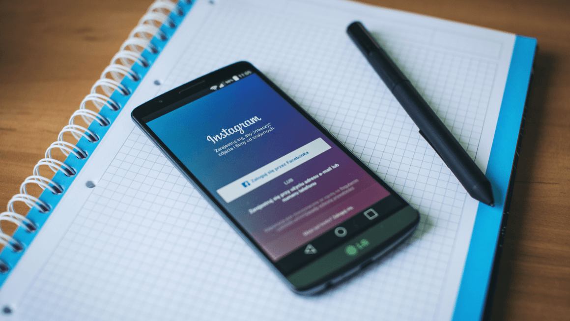 Smart phone showing Instagram log-in screen laying on a notebook